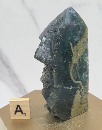 Fluorite crystal on a wooden stand with a marble background