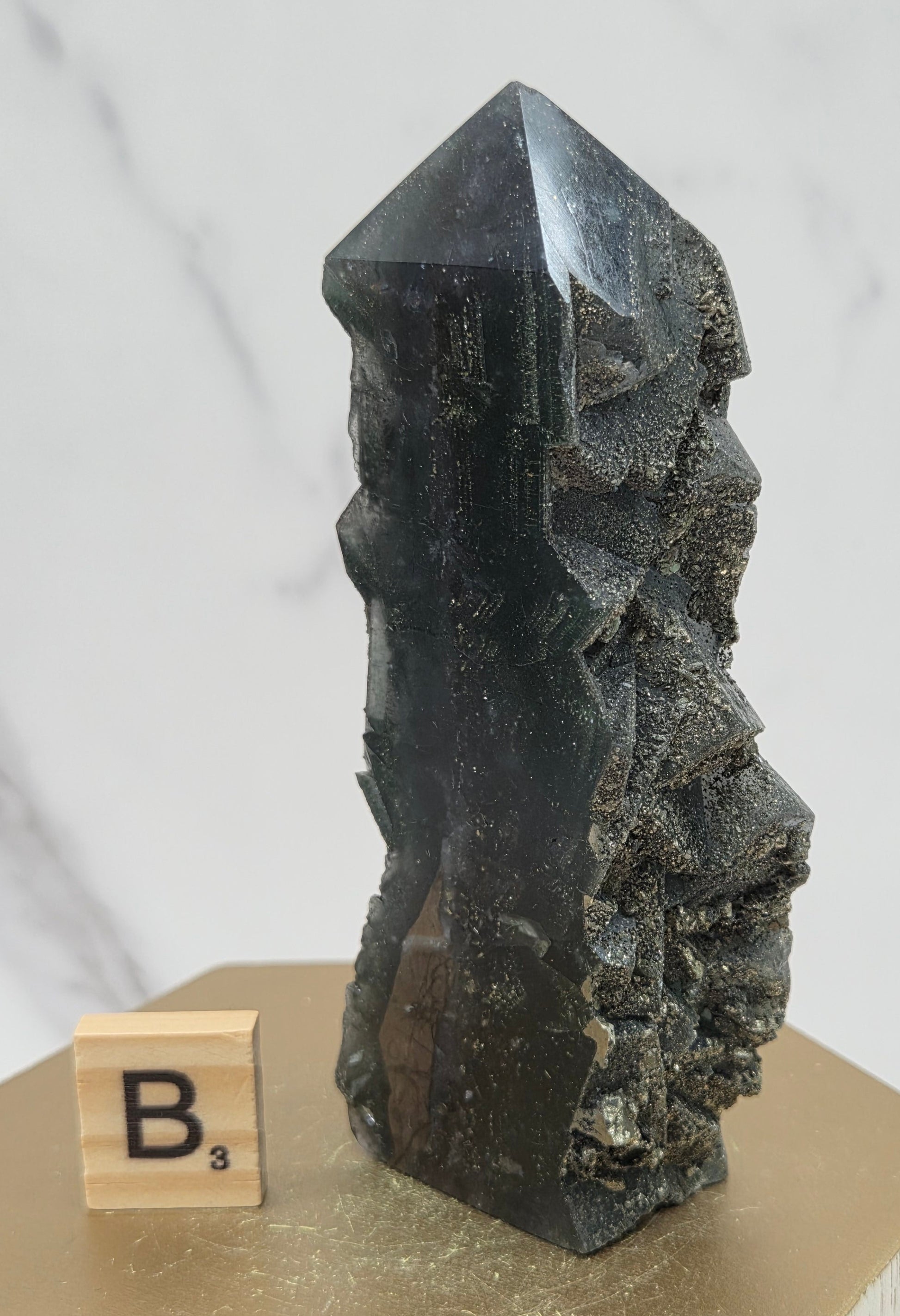 Fluorite crystal on a wooden stand with a marble background