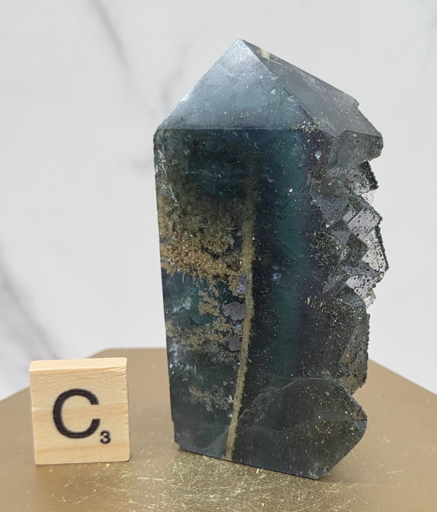 Fluorite crystal on a wooden stand with a marble background