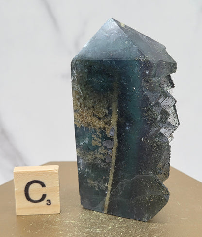 Fluorite crystal on a wooden stand with a marble background
