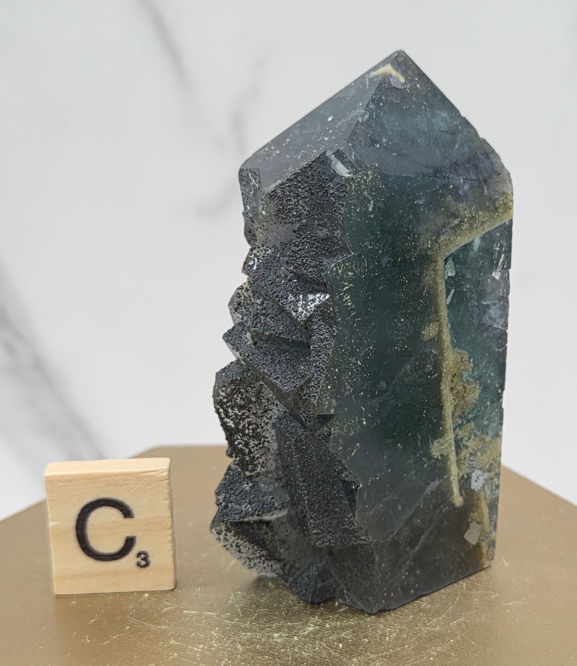 Fluorite crystal on a wooden stand with a marble background
