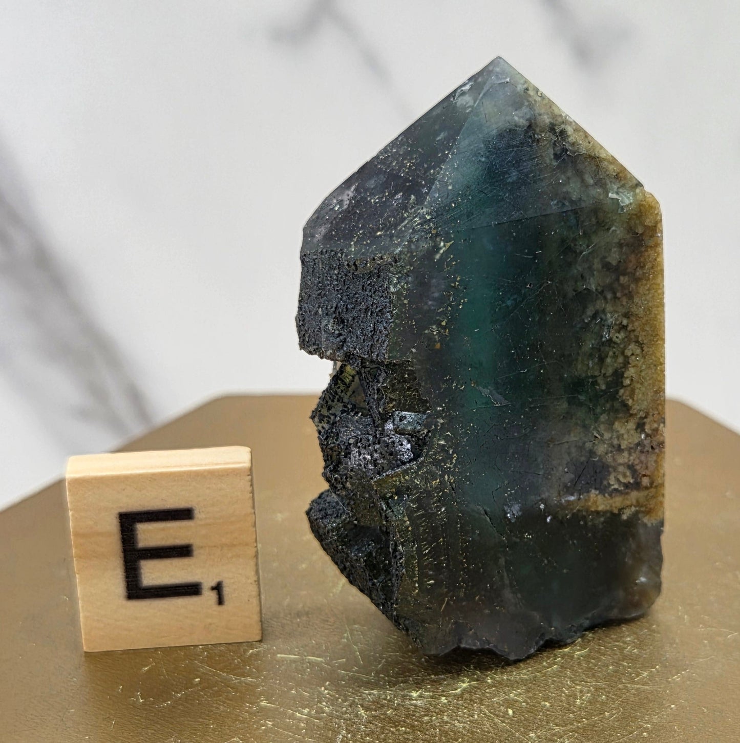 Fluorite crystal on a wooden stand with a marble background