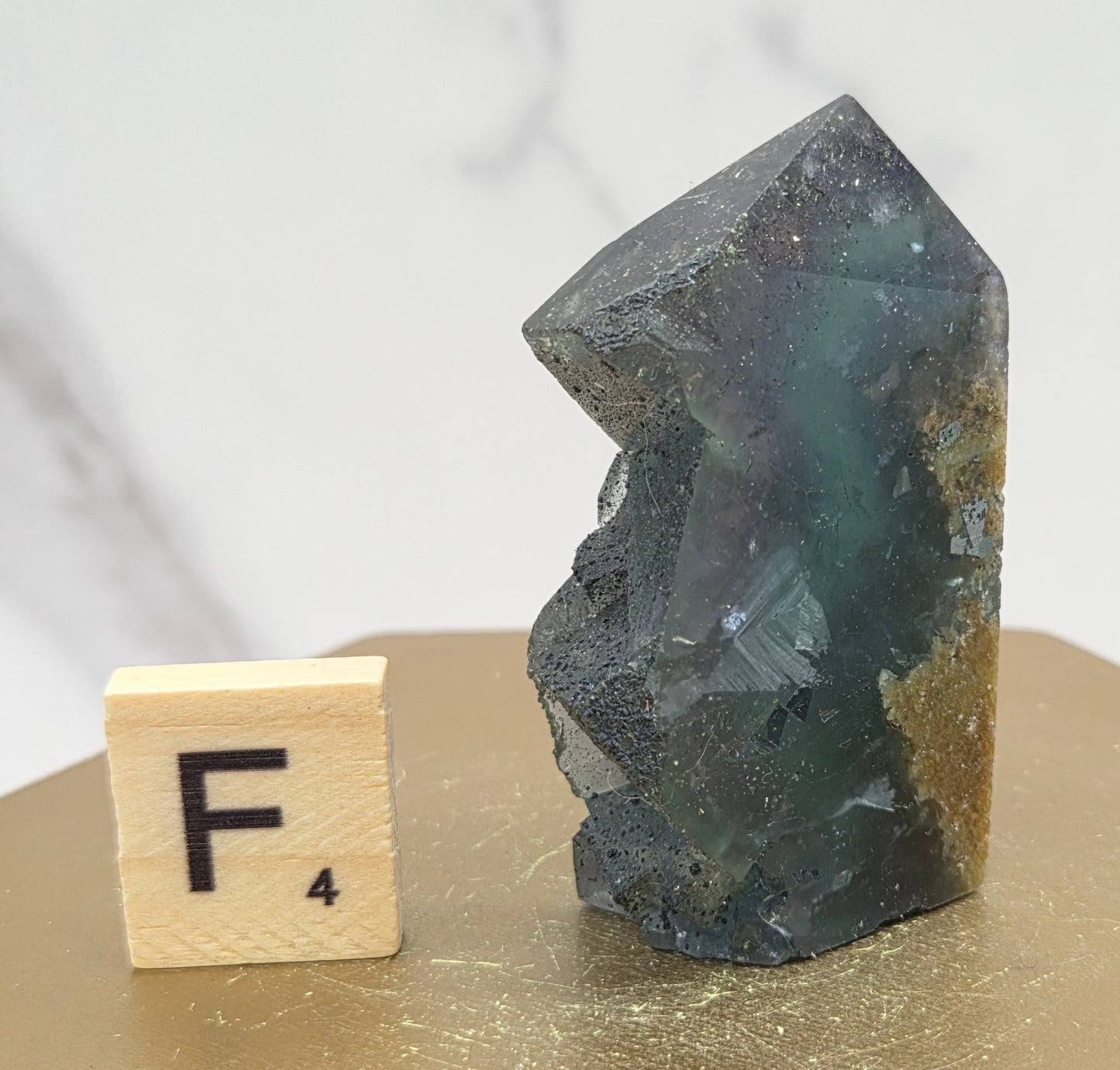 Fluorite crystal on a wooden stand with a marble background