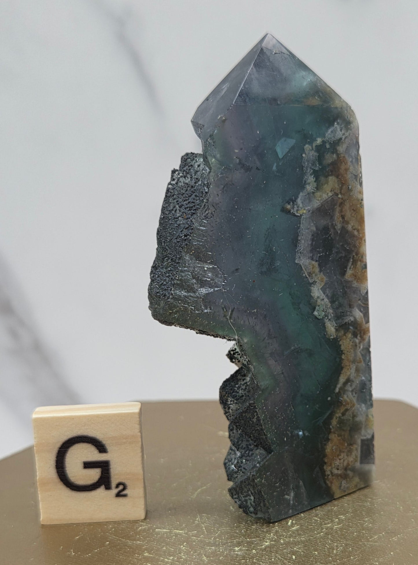 Fluorite crystal on a wooden stand with a marble background