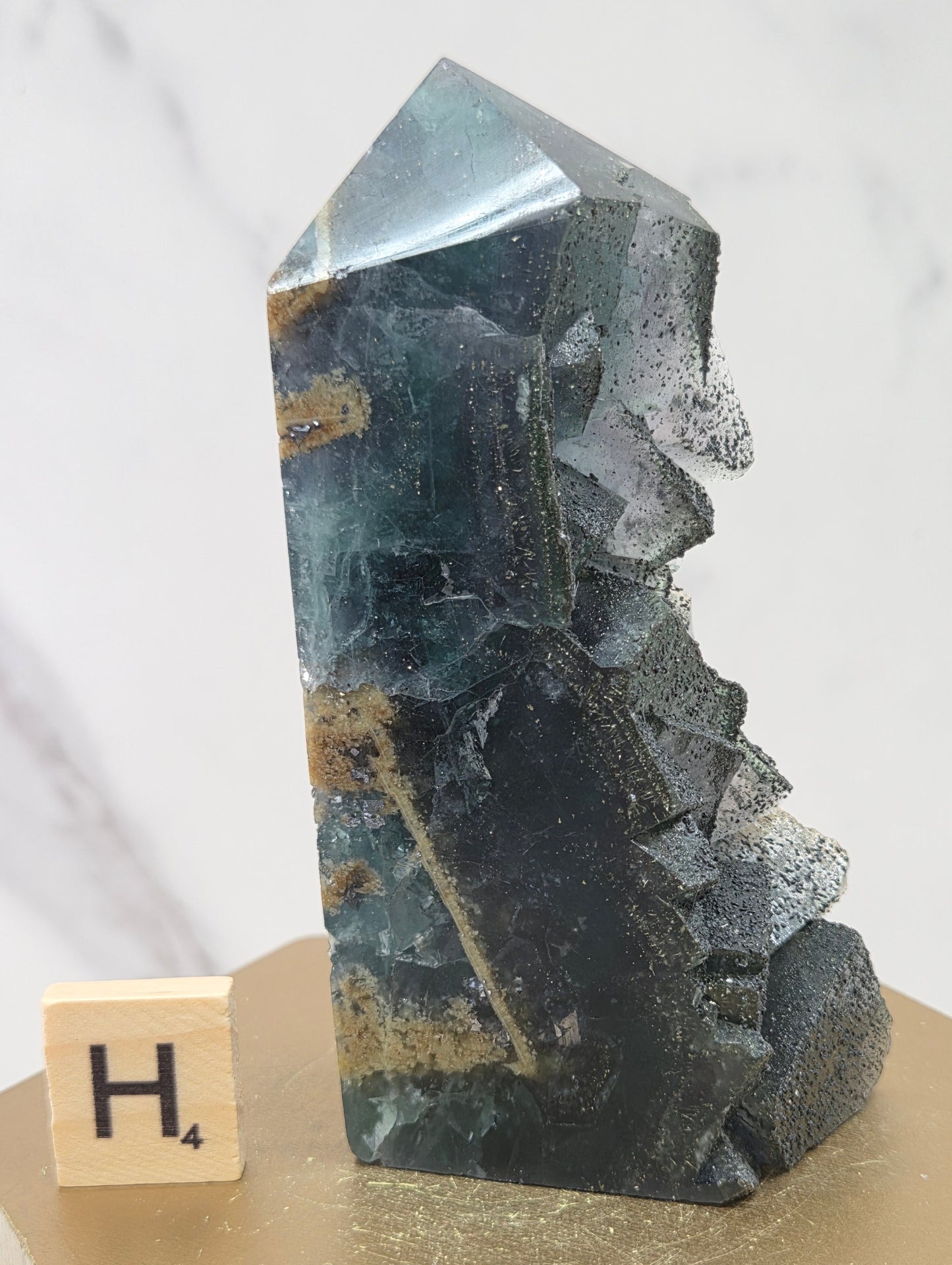 Fluorite crystal on a wooden stand with a marble background
