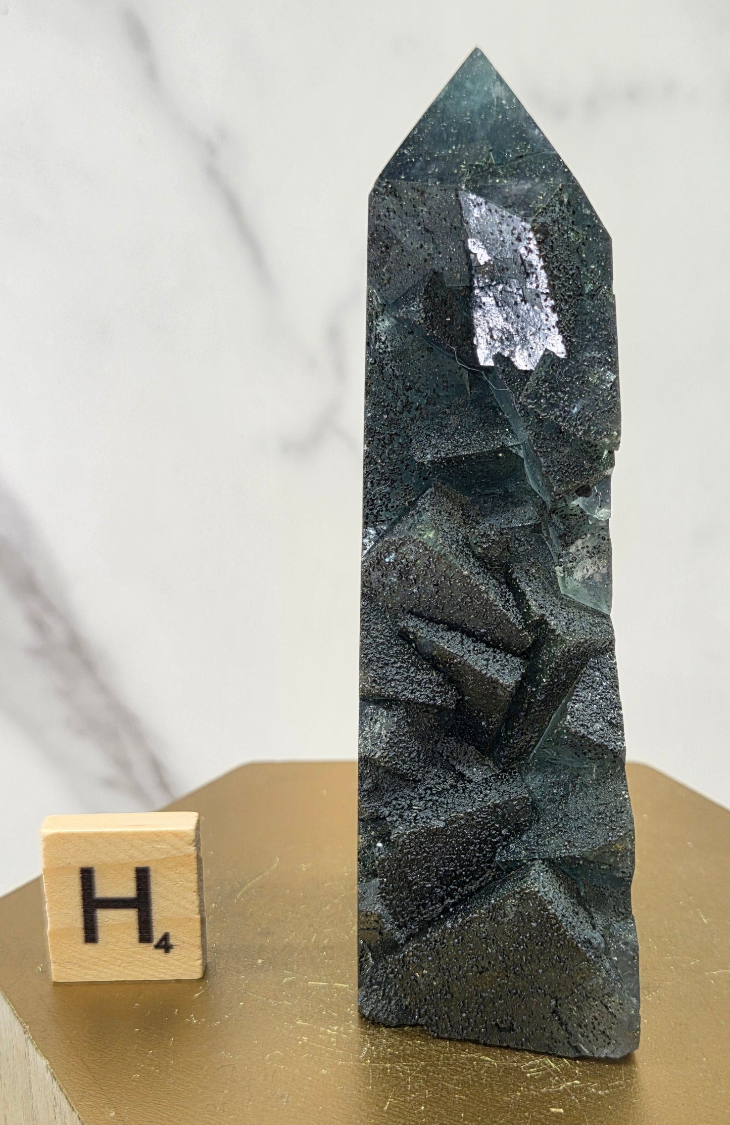 Fluorite crystal on a wooden stand with a marble background