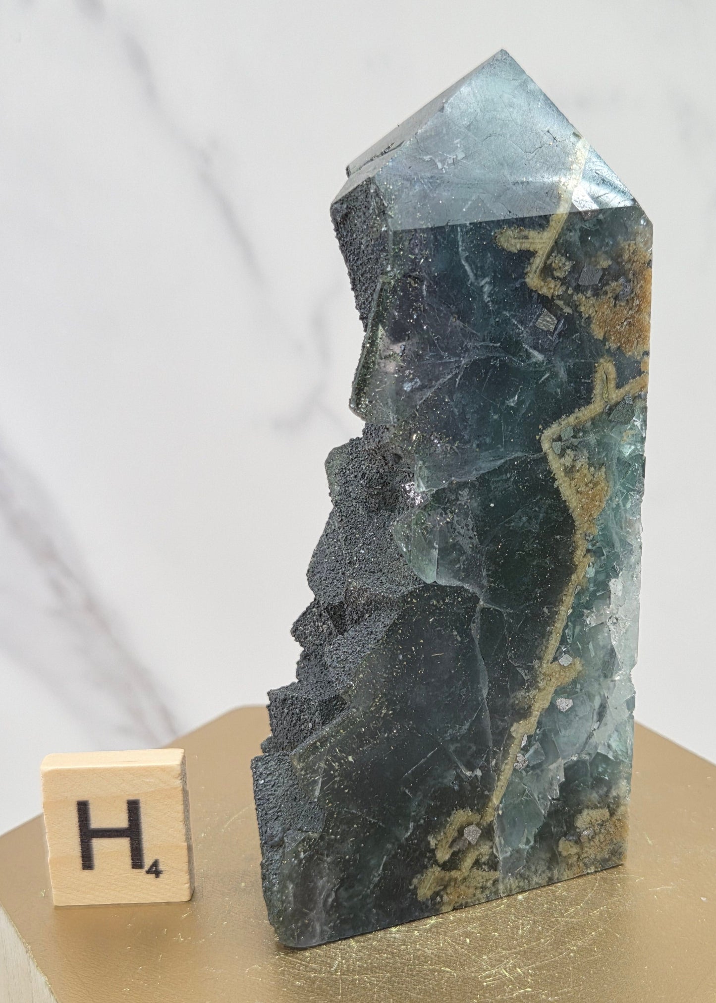 Fluorite crystal on a wooden stand with a marble background