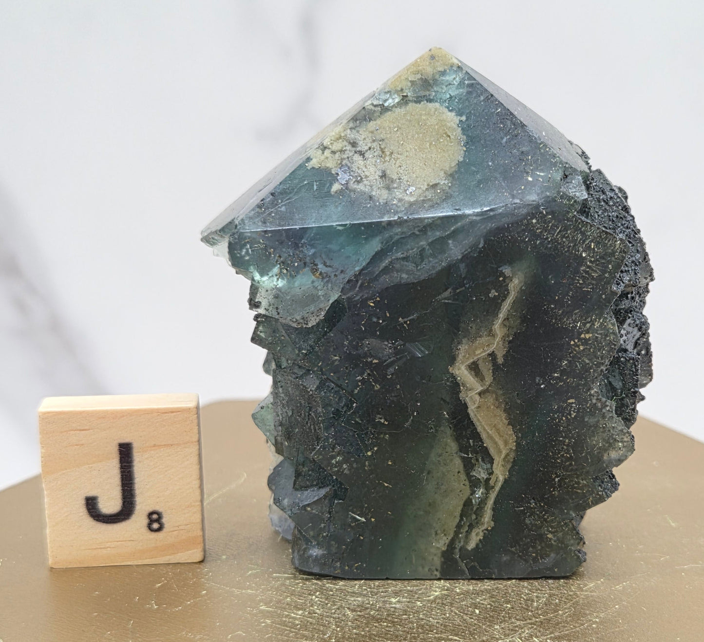 Fluorite crystal on a wooden stand with a marble background