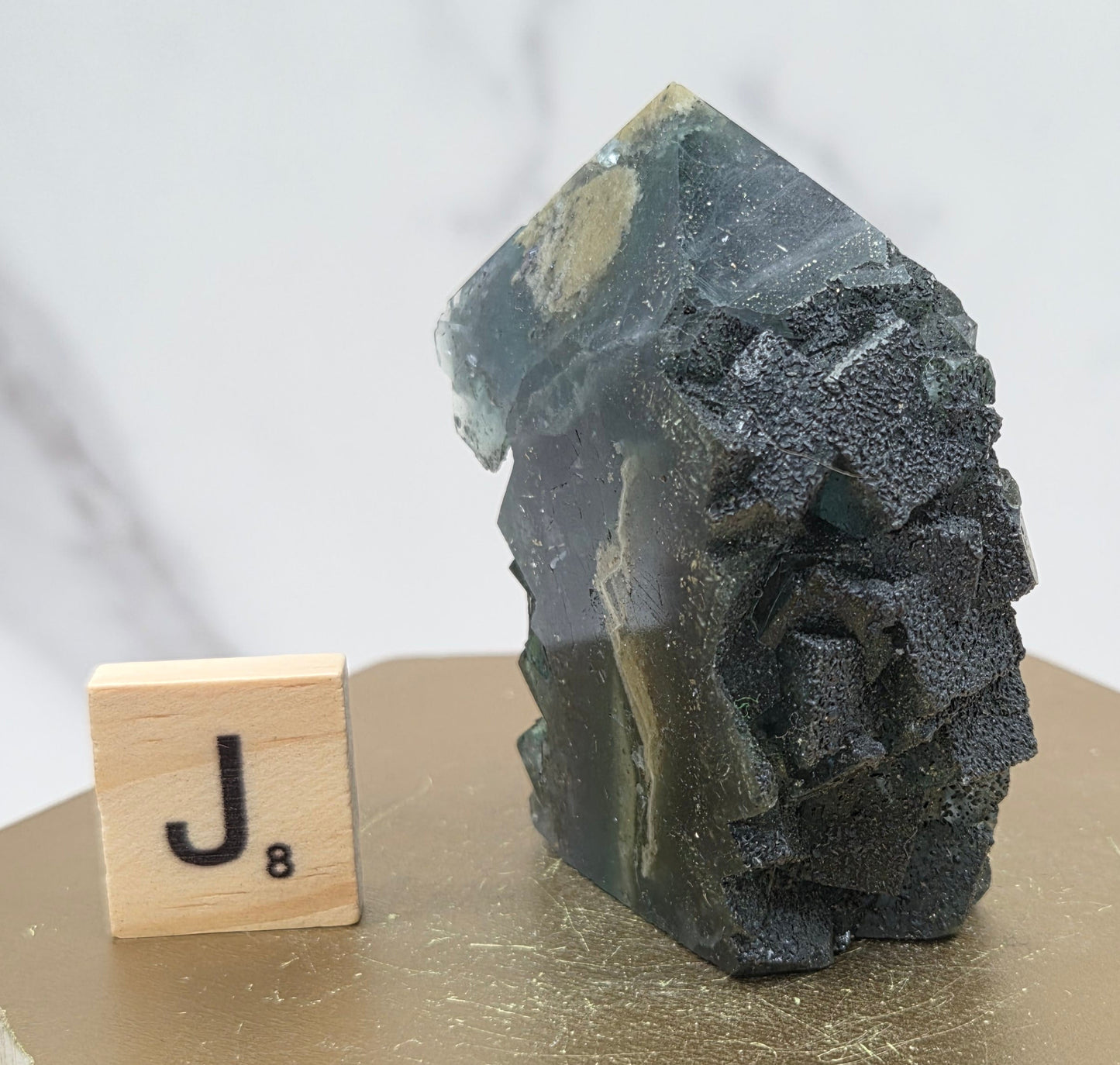 Fluorite crystal on a wooden stand with a marble background