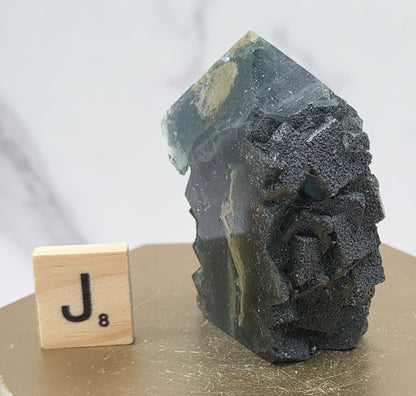Fluorite crystal on a wooden stand with a marble background