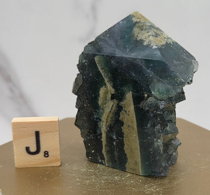 Fluorite crystal on a wooden stand with a marble background