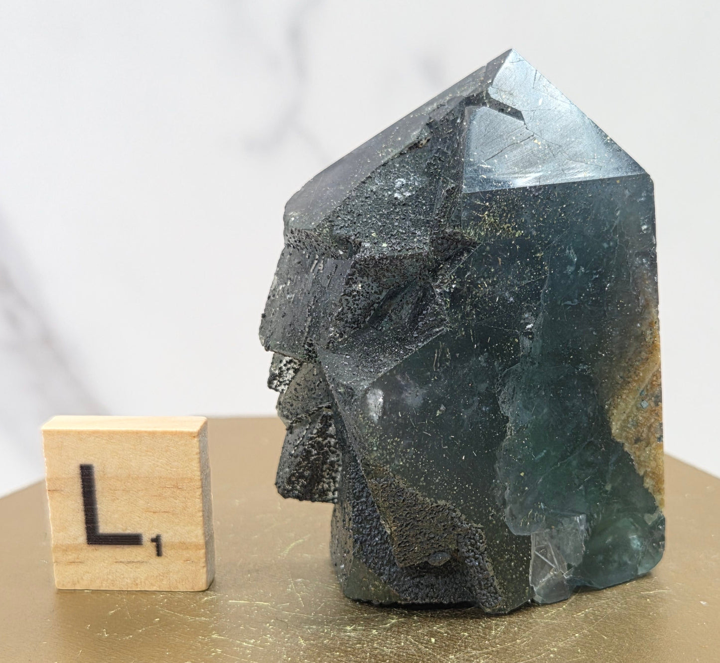 Fluorite crystal on a wooden stand with a marble background