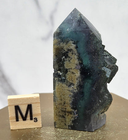 Fluorite crystal on a wooden stand with a marble background