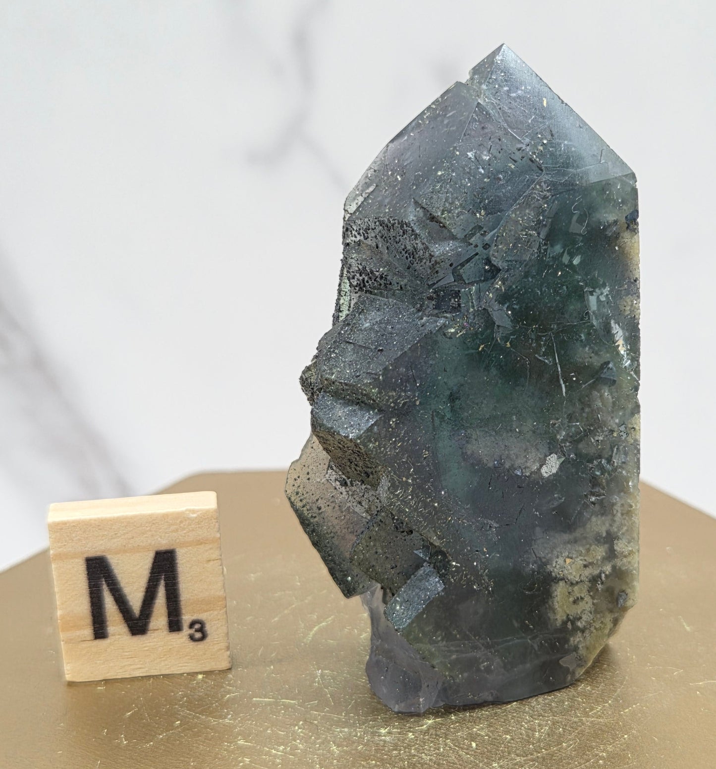 Fluorite crystal on a wooden stand with a marble background