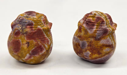 Two colorful Mookaite rose bud carvings on a white background