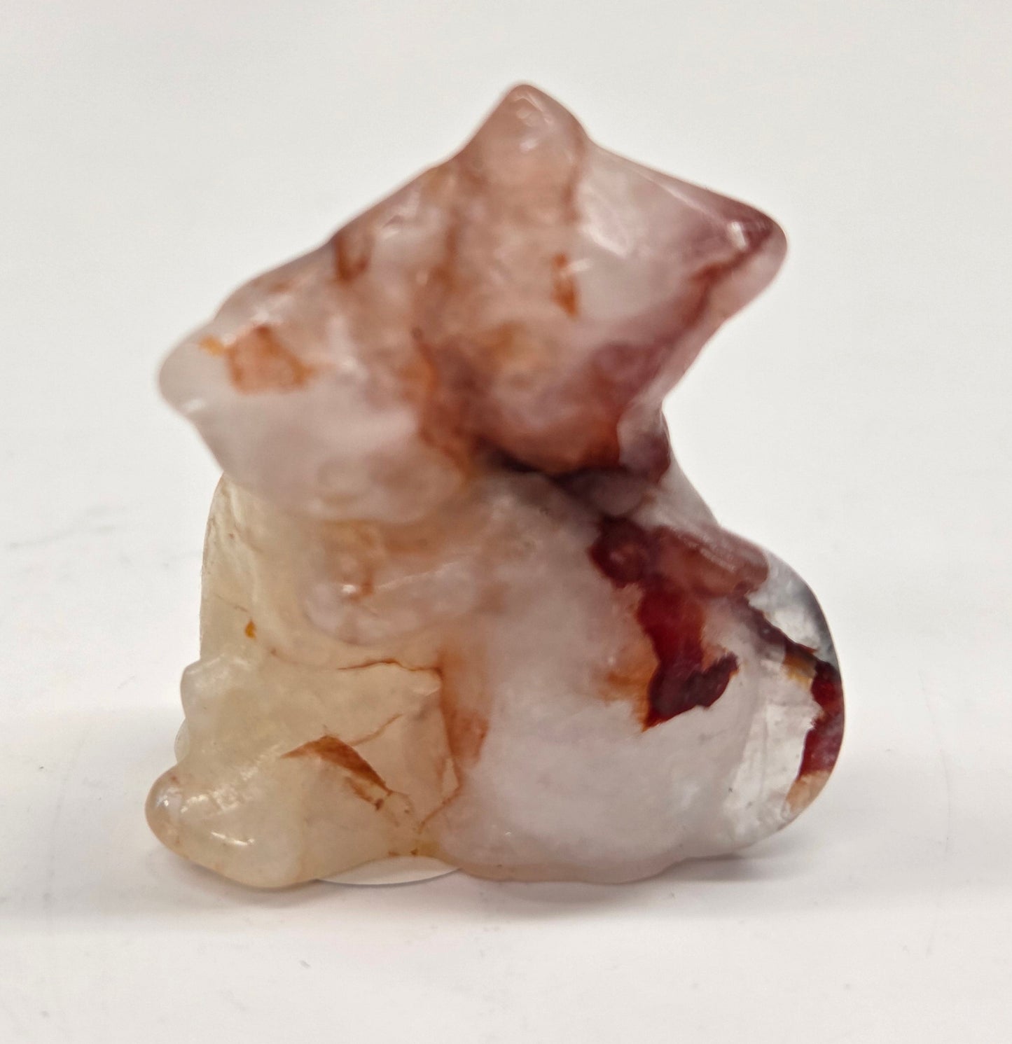 Small, Fire Quartz cat-shaped carvings  placed on a light background.