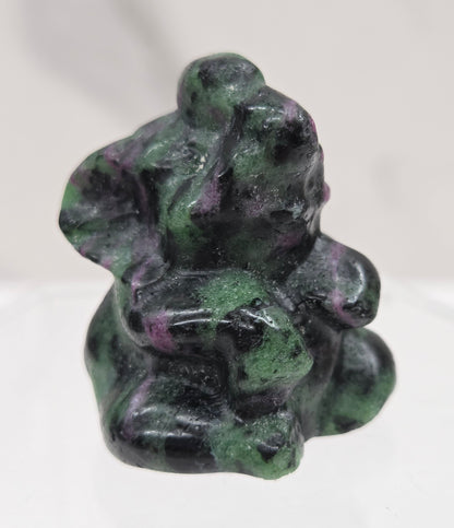 Green, black & pink Ruby Zoisite  sitting elephant carving on a white background
