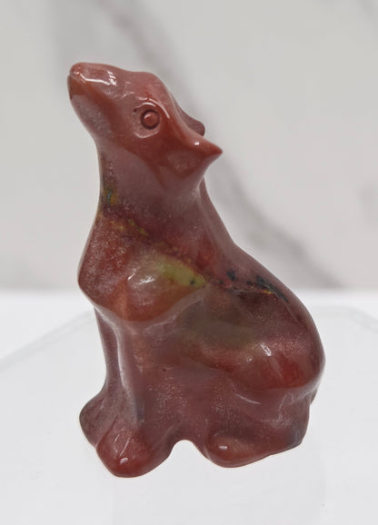 Red Mookaite carving of a wolf on a white background