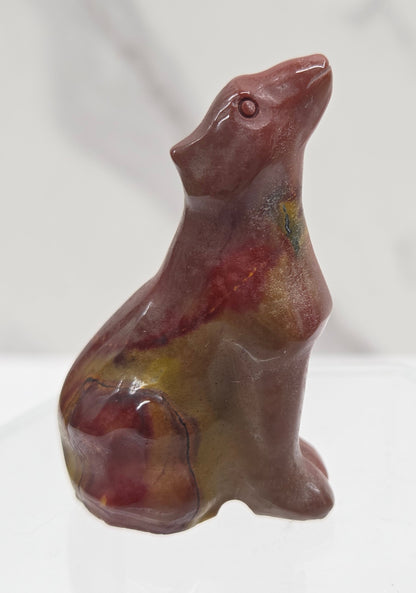 Red Mookaite carving of a wolf on a white background
