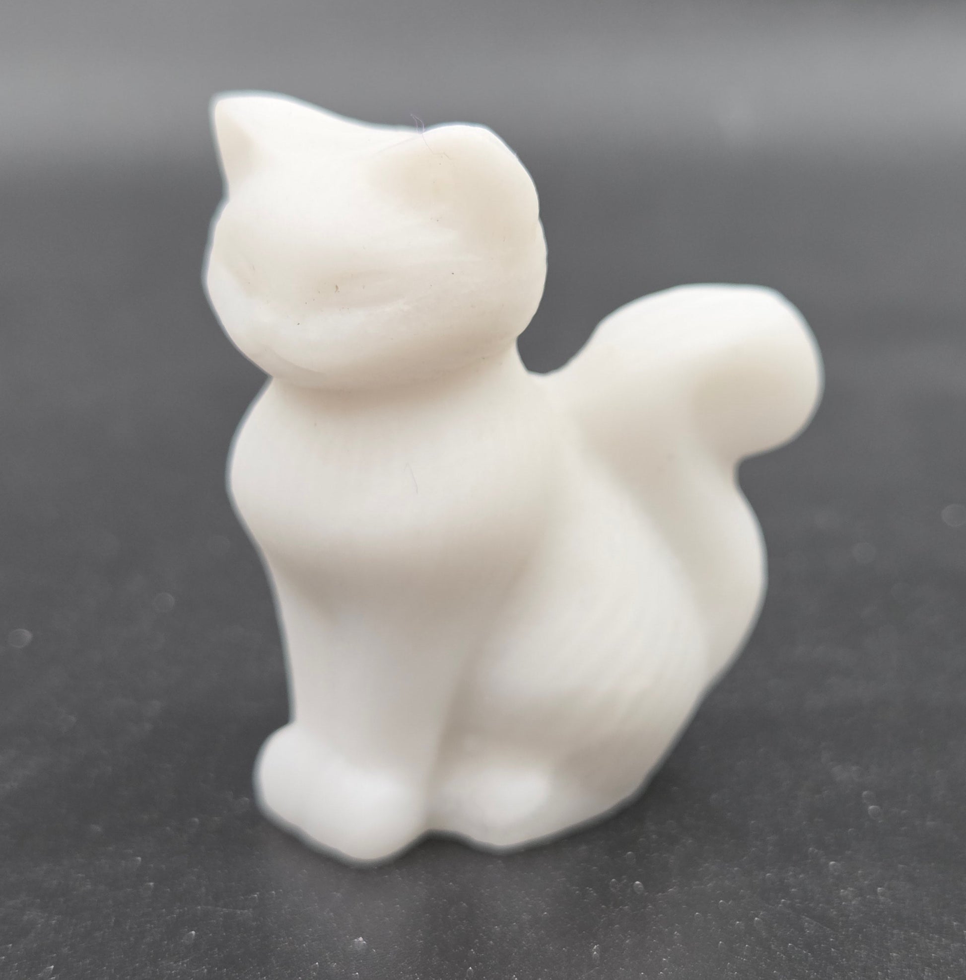 small White Jade sculpture of a cat against a neutral background