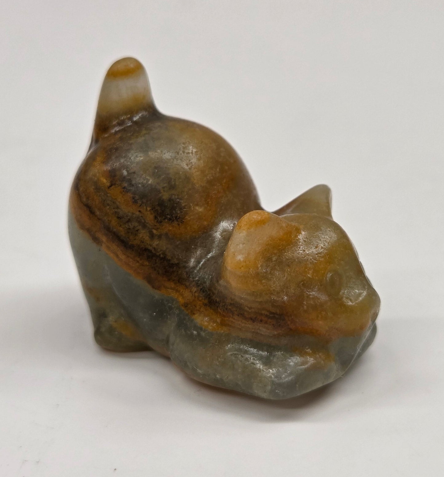 Small stone sculpture of a cat on a white background