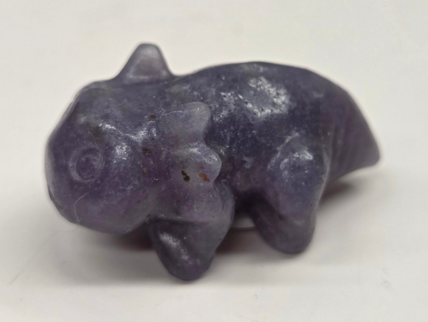 Purple stone figurine of an axolotl on a white background