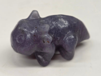 Purple stone figurine of an axolotl on a white background