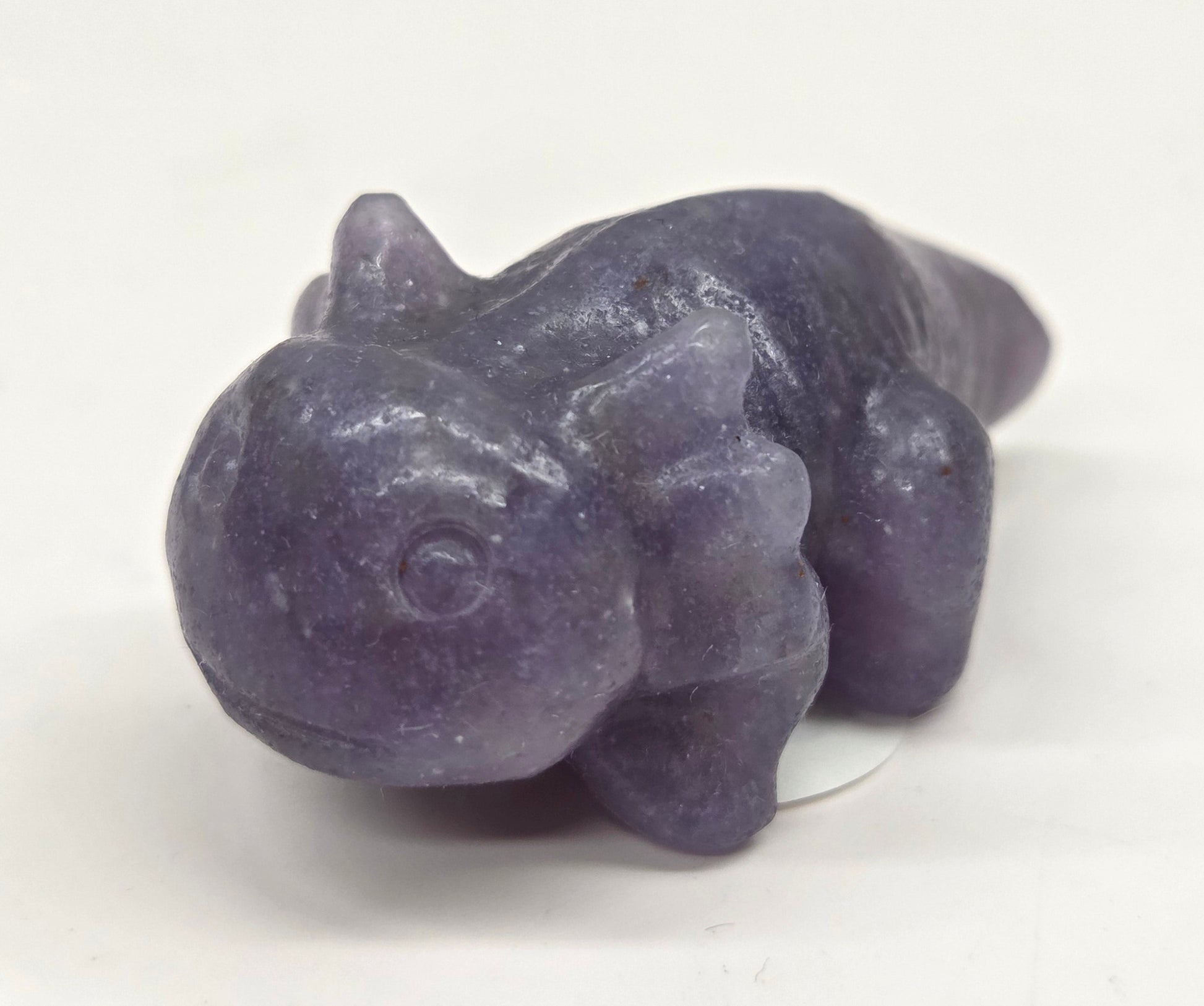 Purple stone figurine of an axolotl on a white background