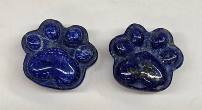 Two blue paw print-shaped objects on a white background