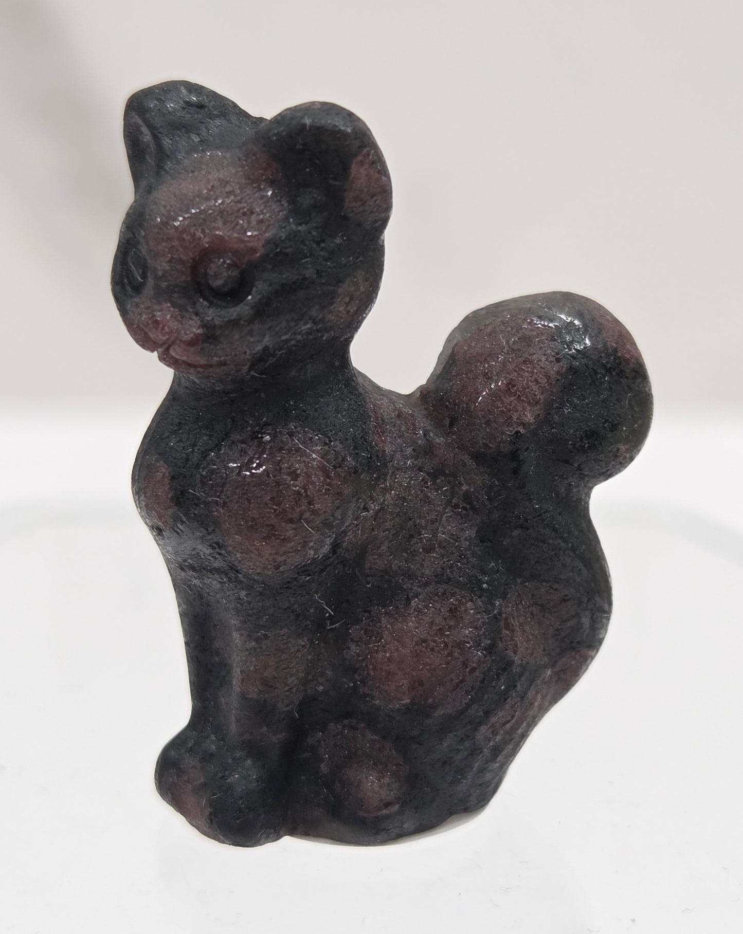 small black & red Garnet sculpture of a cat against a neutral background