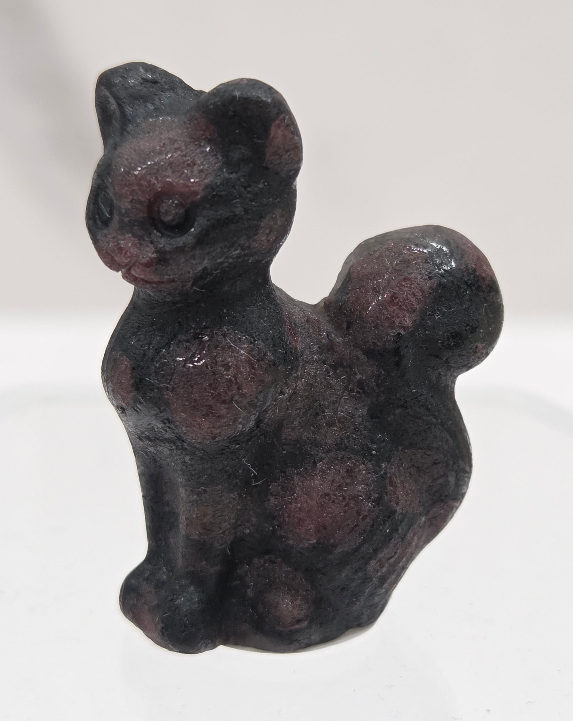 small black & red Garnet sculpture of a cat against a neutral background