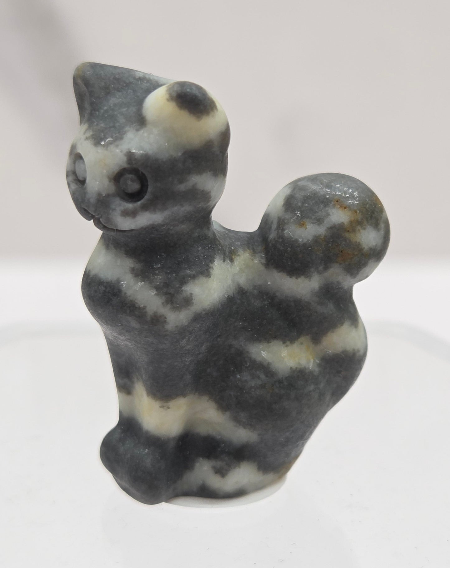 small banded Zebra Jasper sculpture of a cat against a neutral background