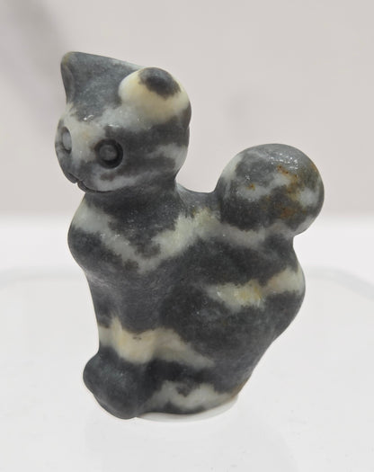 small banded Zebra Jasper sculpture of a cat against a neutral background