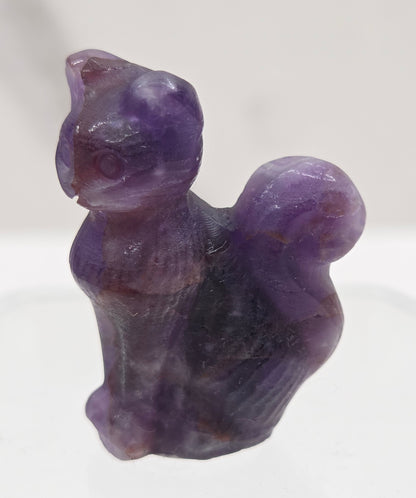 small amethyst sculpture of a cat against a neutral background