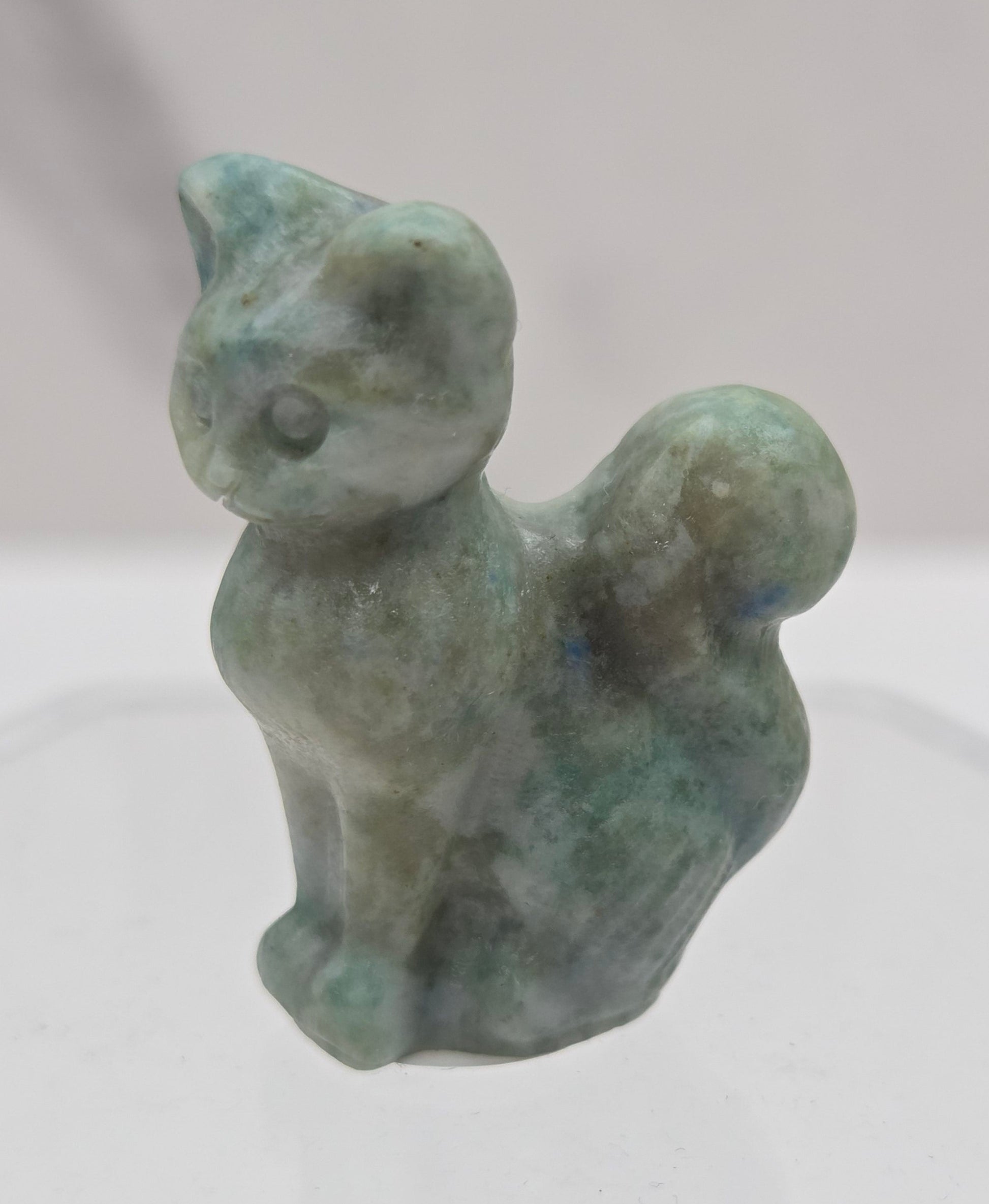 small light green jade sculpture of a cat against a neutral background