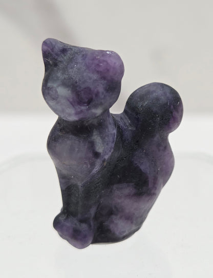 small purple Lepidolitte sculpture of a cat against a neutral background