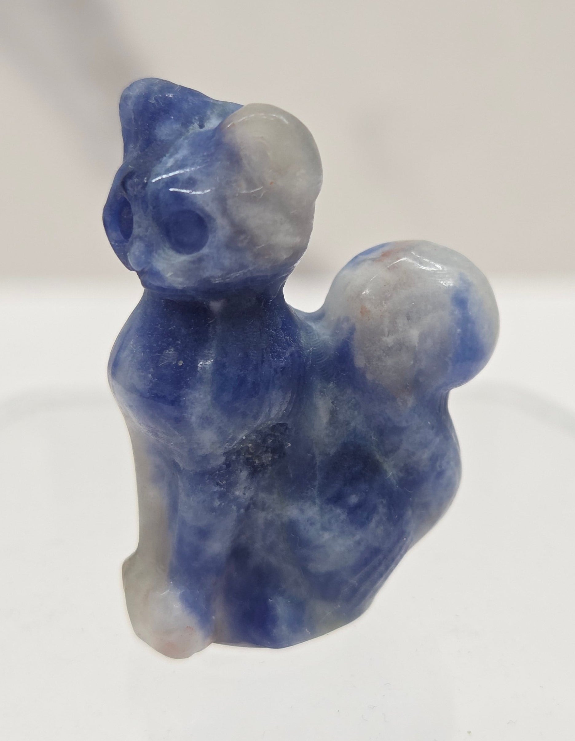small blue & white Sodalite sculpture of a cat against a neutral background