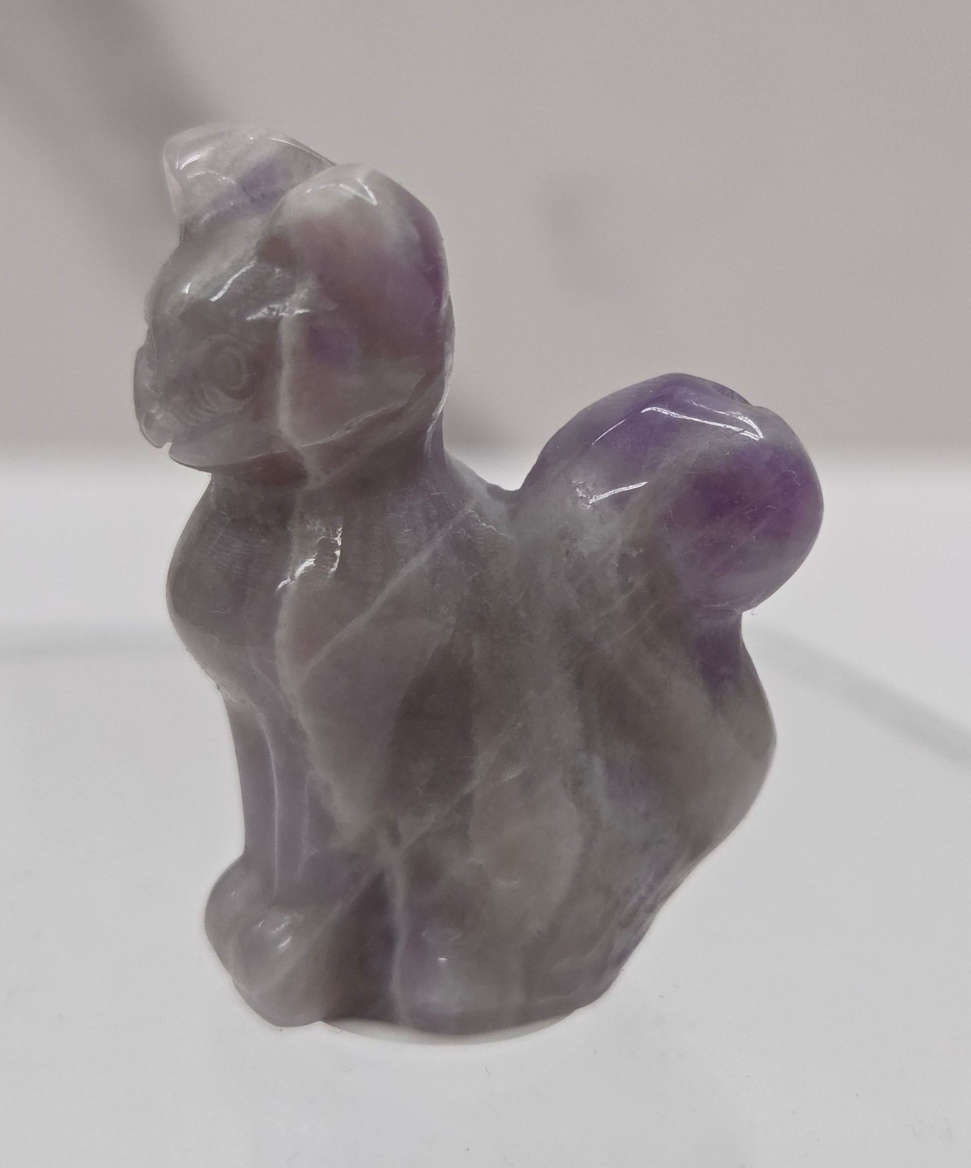 small Dream Amethyst sculpture of a cat against a neutral background