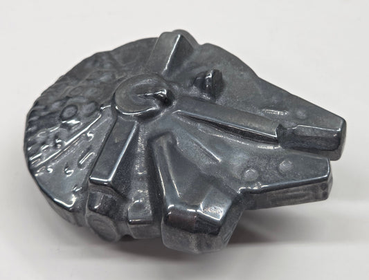 Metallic looking Millennium Falcon carving on a white background