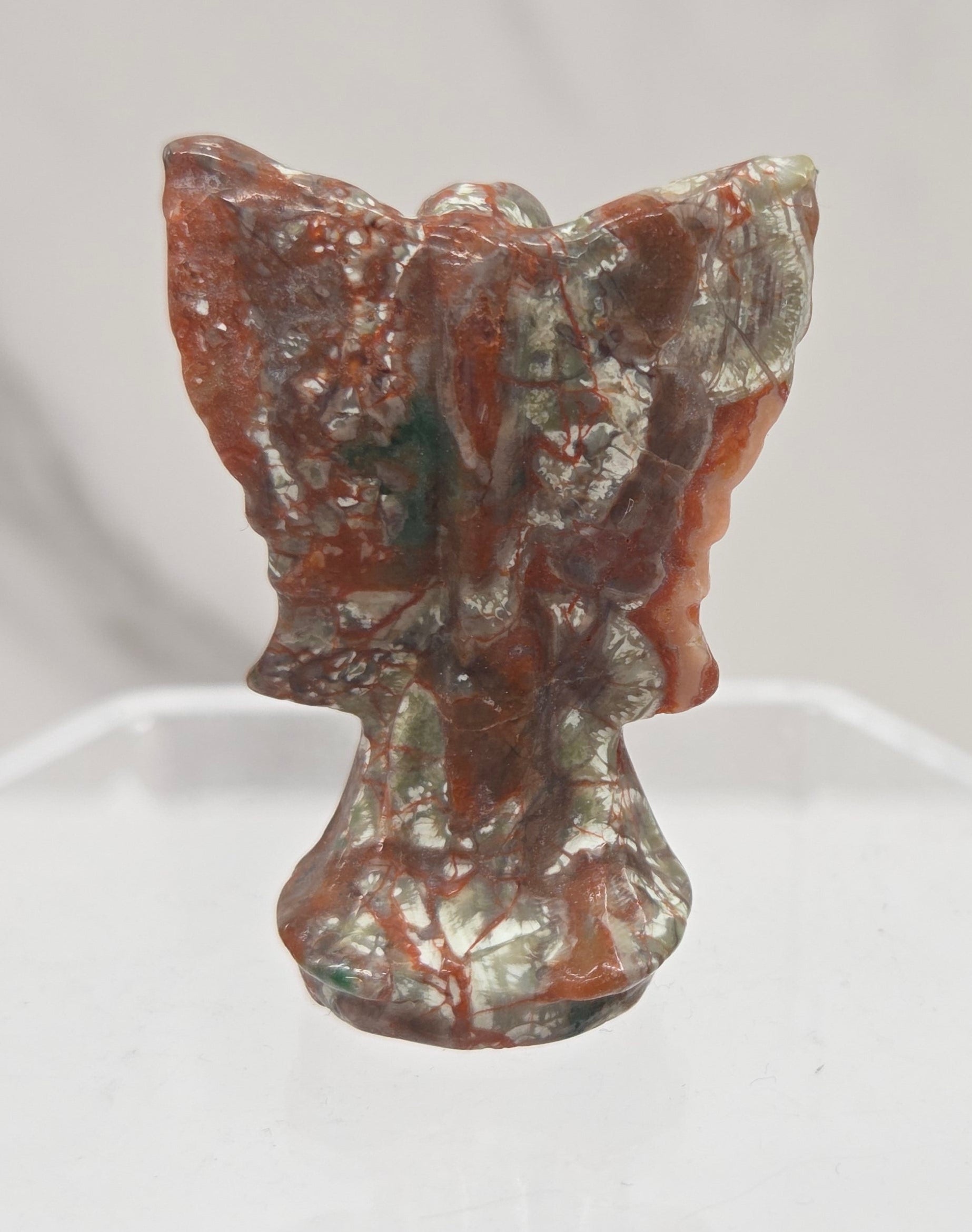 Small Money Agate angel carving on a white background