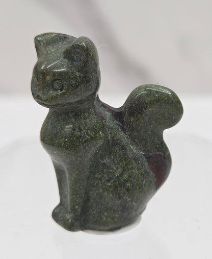small green Dragons Blood sculpture of a cat against a neutral background