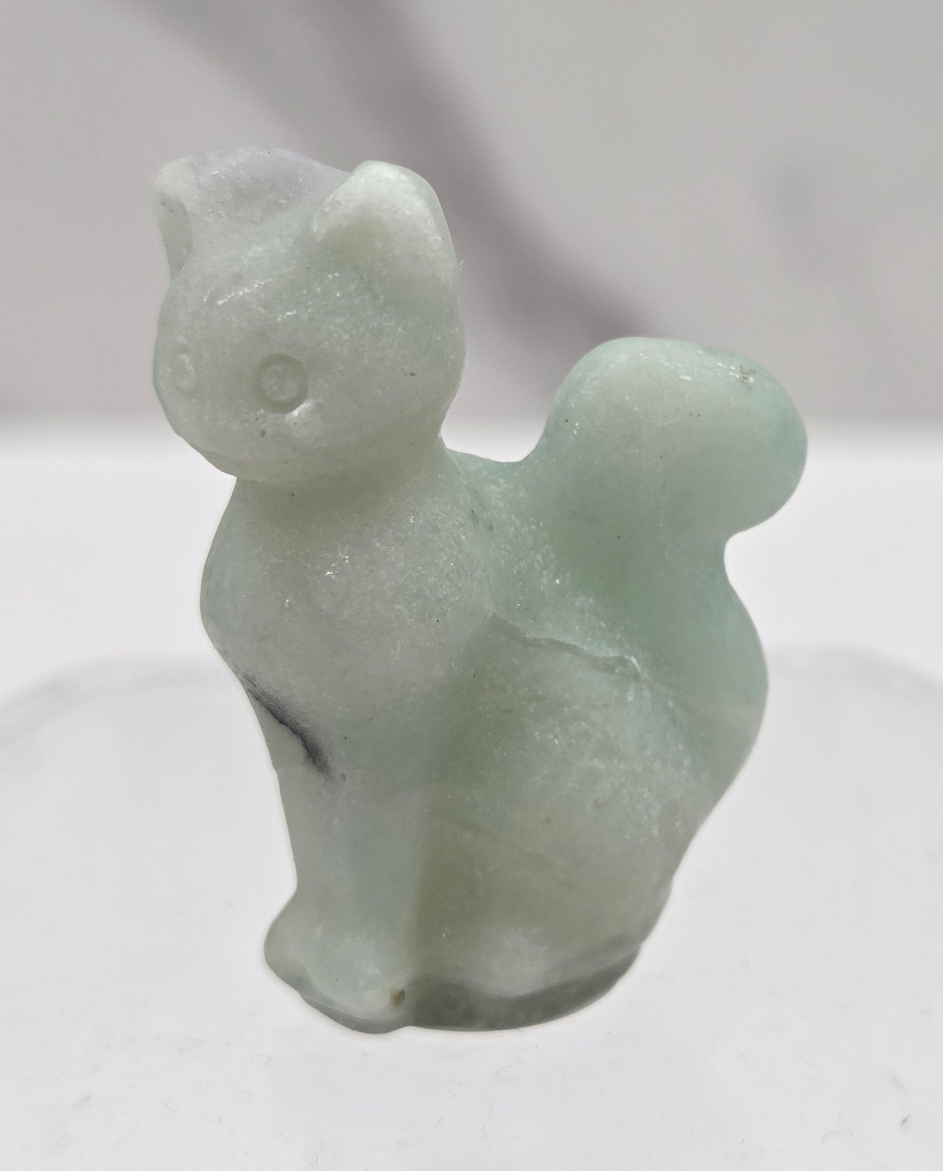 small light blue Caribbean Calcite sculpture of a cat against a neutral background