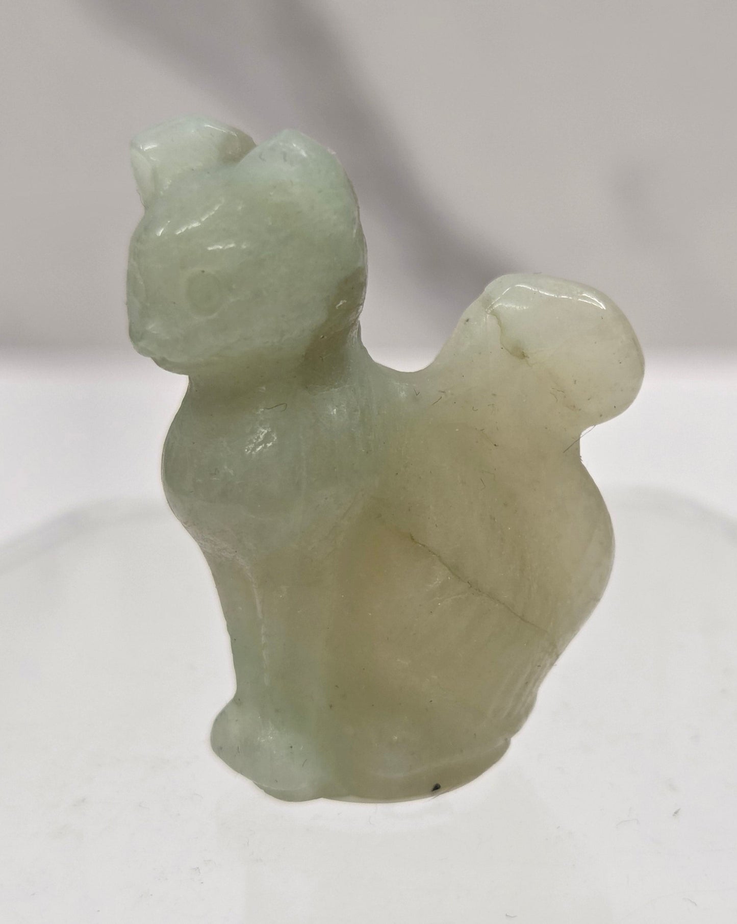 small Caribbean Calcite sculpture of a cat against a neutral background
