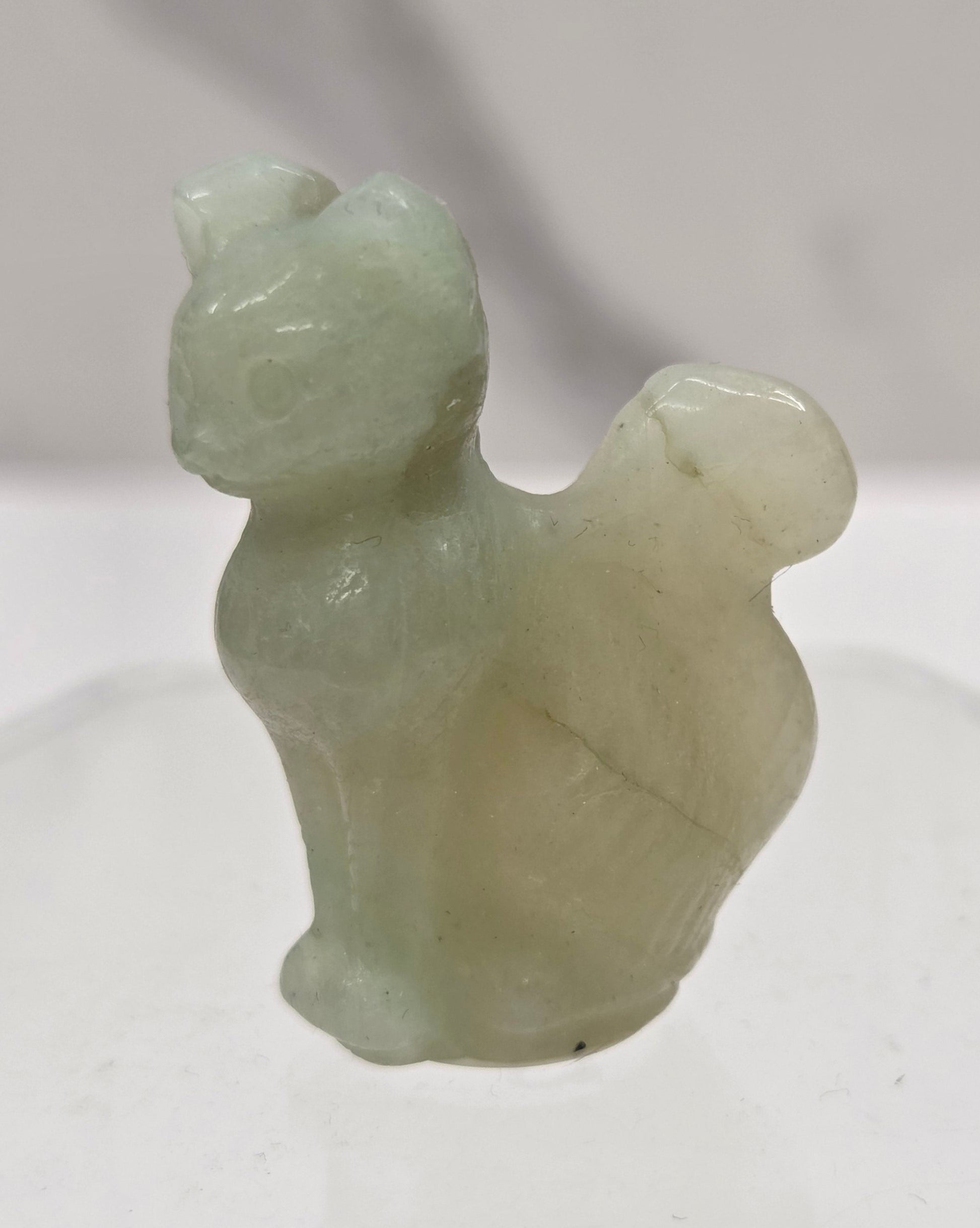 small Caribbean Calcite sculpture of a cat against a neutral background