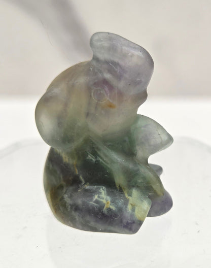 Multicolored sitting elephant carving on a white background