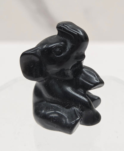 Obsidian sitting elephant carving on a white background