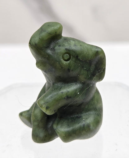Green Jade sitting elephant carving on a white background