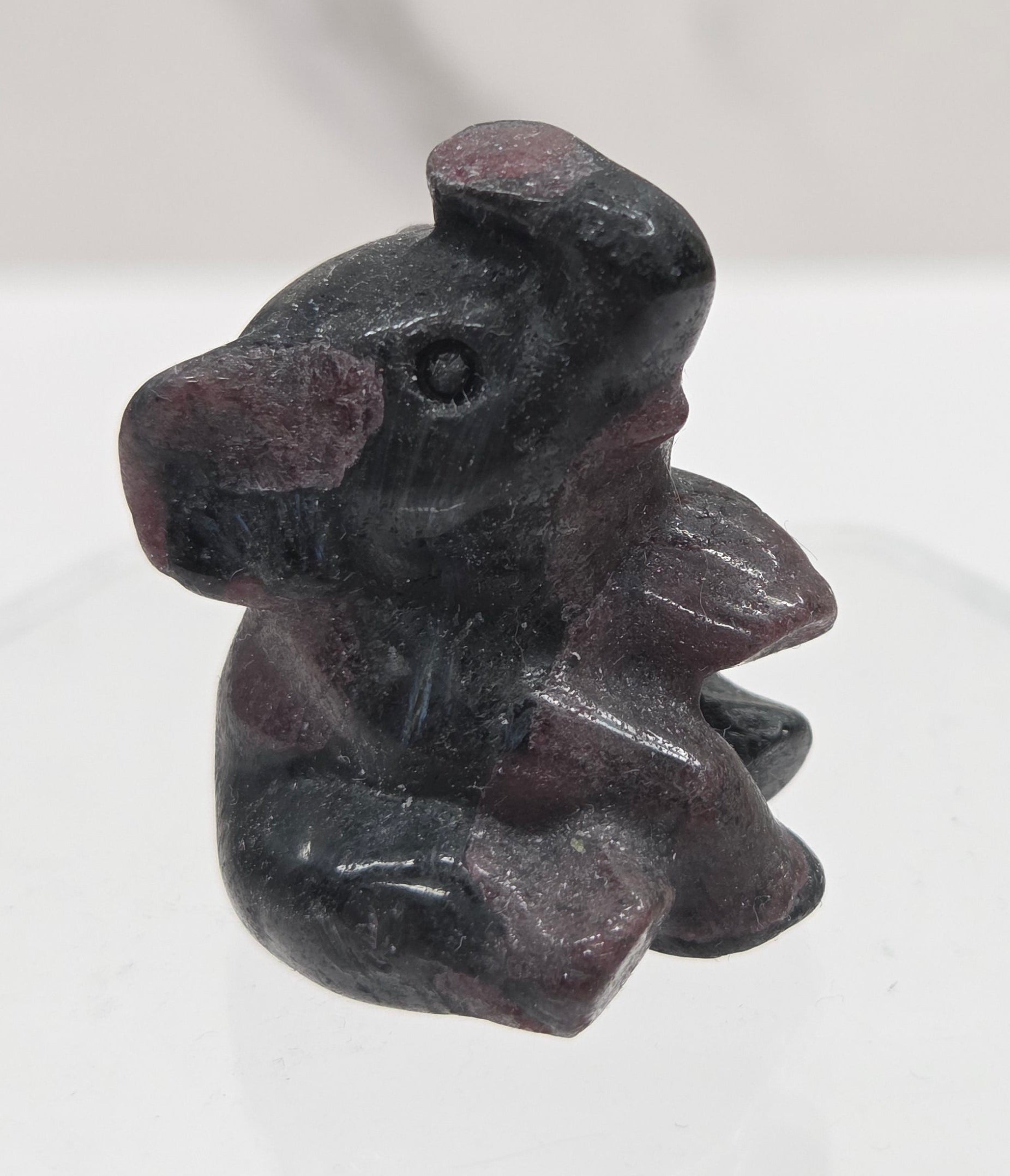 Black and red Garnet sitting elephant carving on a white background