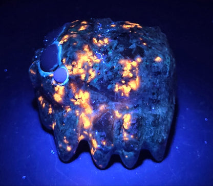 Yooperlite jumping spider carving on a white background under UV light