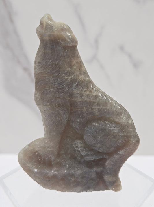 Moonstone carving of a wolf on a white background